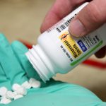 A pharmacist poses with pills of the drug Misoprostol, made by Lupin Pharmaceuticals, in his hand at a pharmacy in Provo